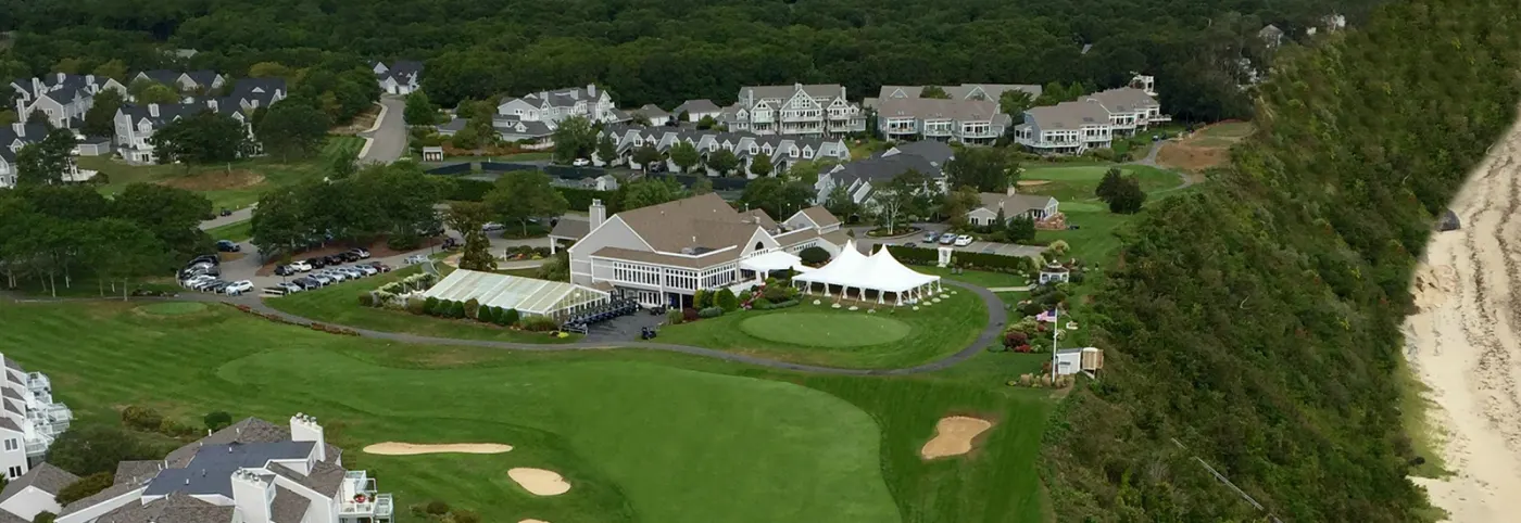Aerial view of the White Cliffs clubhouse, tent and golf course above the bay