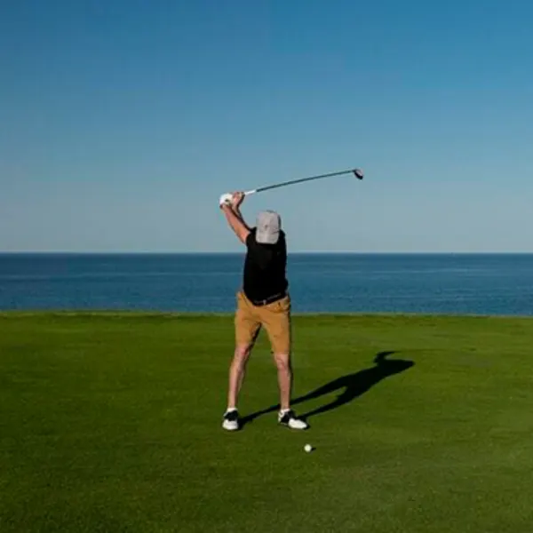 Golfer finishing a swing above the bay